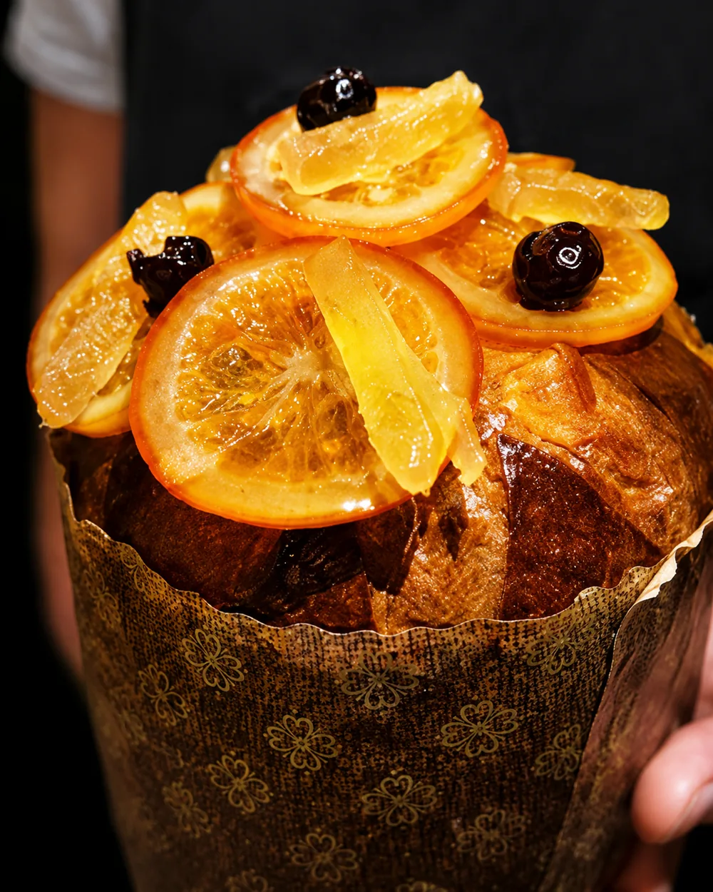 Panetone artesanal decorado com laranja cristalizada e frutas secas, ideal para encomendas de festas